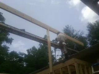 Carpenter setting a ridge beam over a new addition frame — Ice Dam Removal by Roofing Brothers in East Smithfield