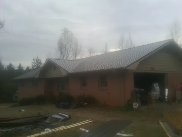 Gray metal roof on a stucco house with an attached garage in East Smithfield