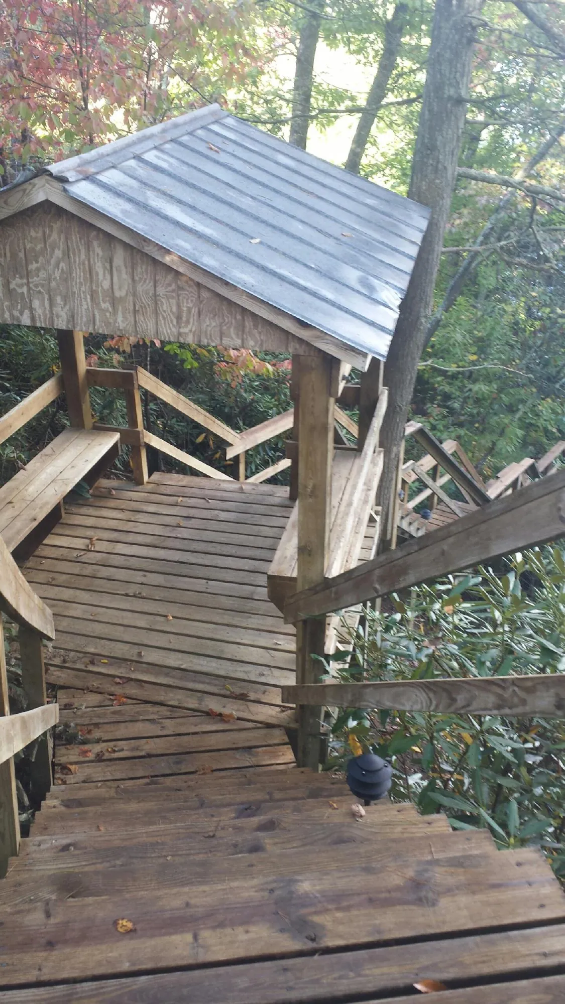 Metal roofed shelter over wooden steps on a wooded walkway — Skylight Repair & Installation work by our crew in East Smithfield