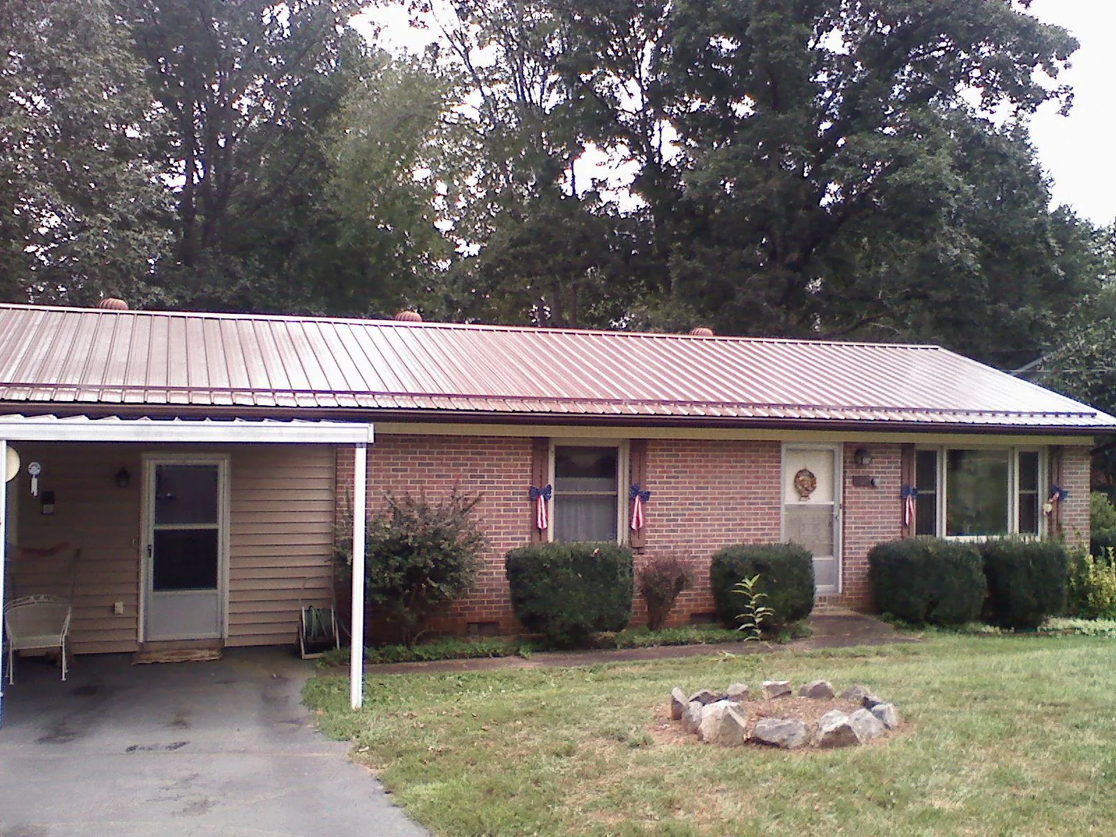 Bronze metal roof and carport on a brick ranch home — Roof Repair work by our crew in East Smithfield
